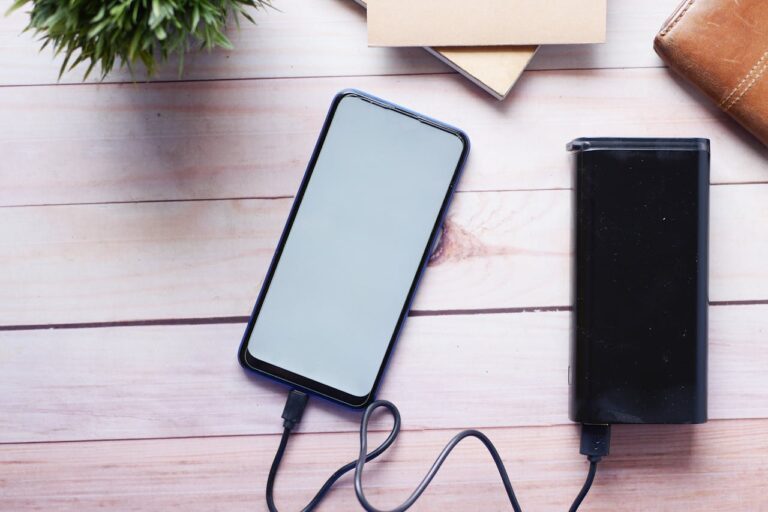 A mobile phone with a power bank plugged in is on the table.